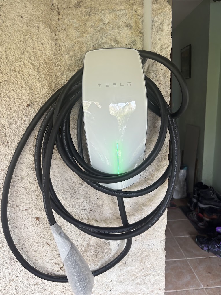 Électricien IRVE à Bourges – Installation de bornes de recharge Borne Tesla installée sur un mur en pierre