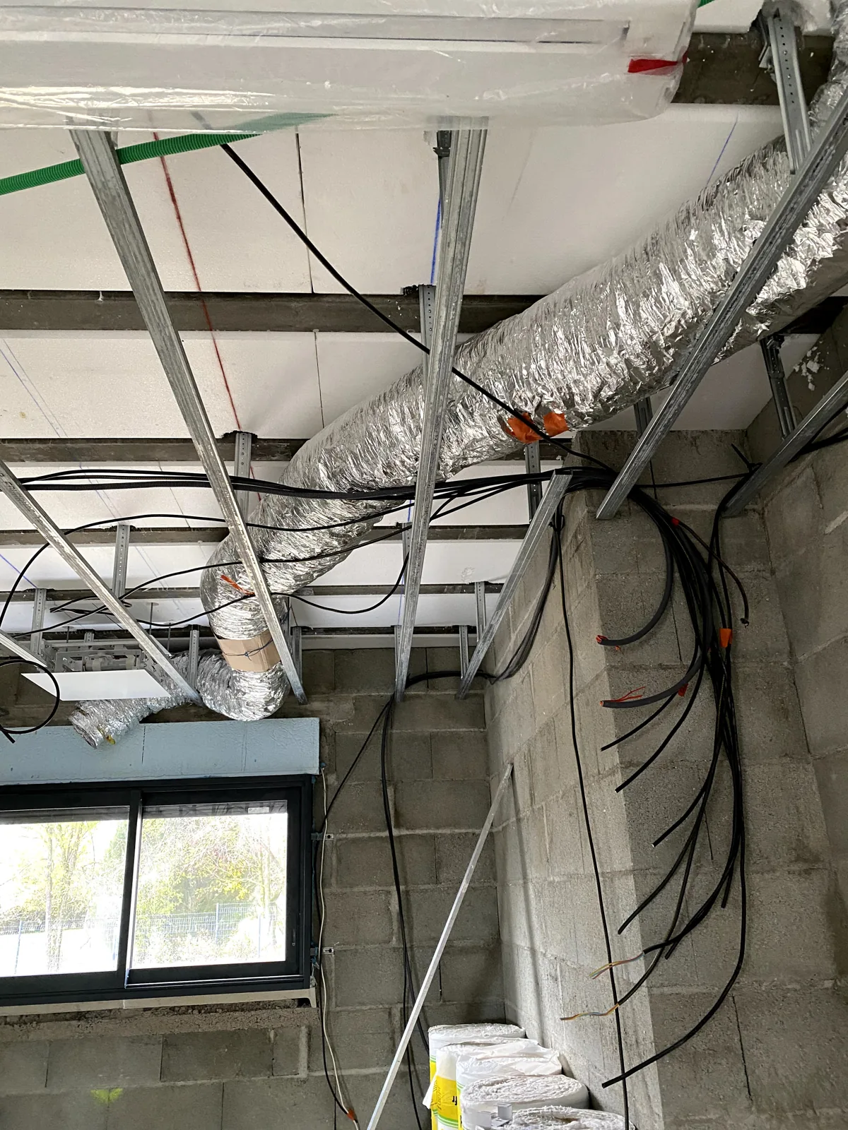 Climatisation à Bourges – Installation réversible par POSELEC Pose des gaines dans l’ossature du faux plafond — chantier POSELEC