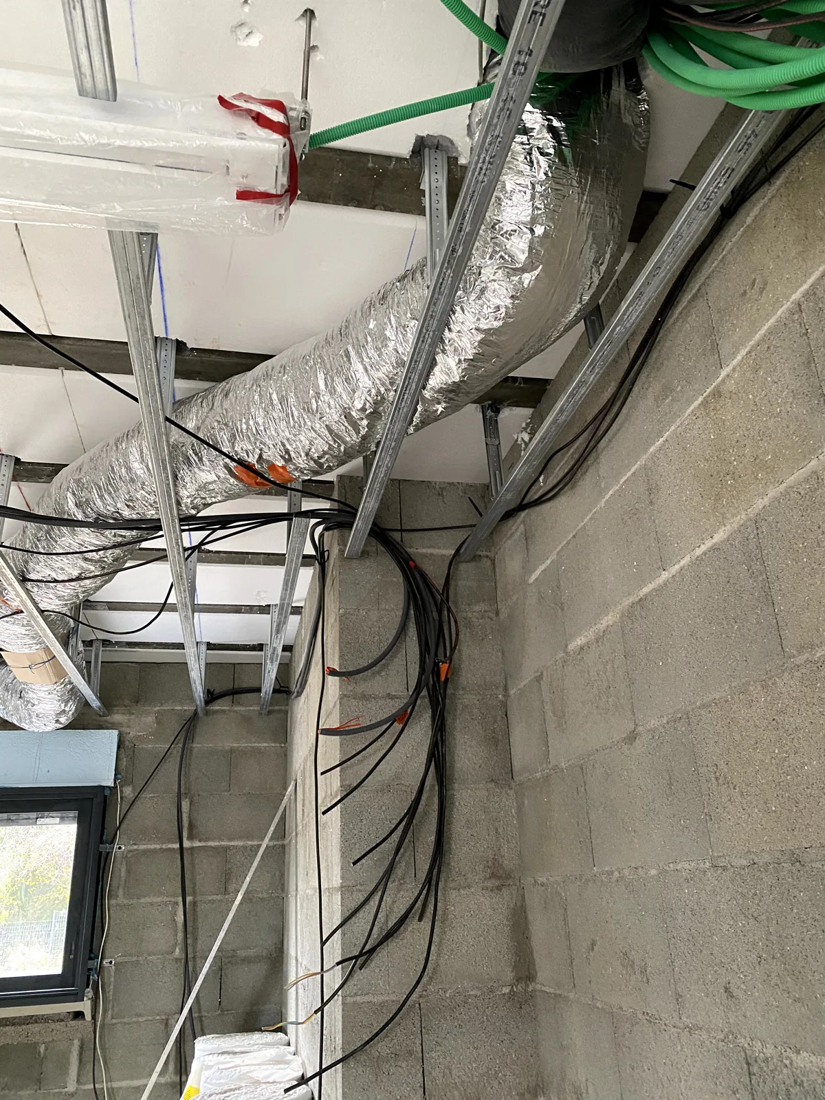 Climatisation à Bourges – Installation réversible par POSELEC Cheminement des gaines isolées au-dessus du faux plafond — chantier POSELEC